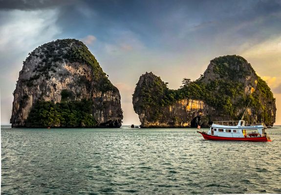Limestone cliffs in the sea, with a boat in the foreground
